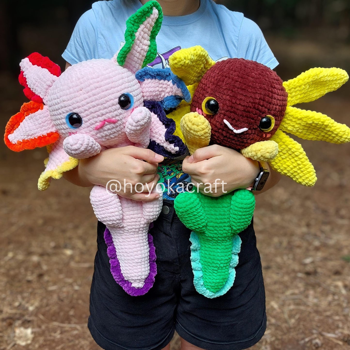 Person holding three colorful crochet sea creature toys with a blurred background.